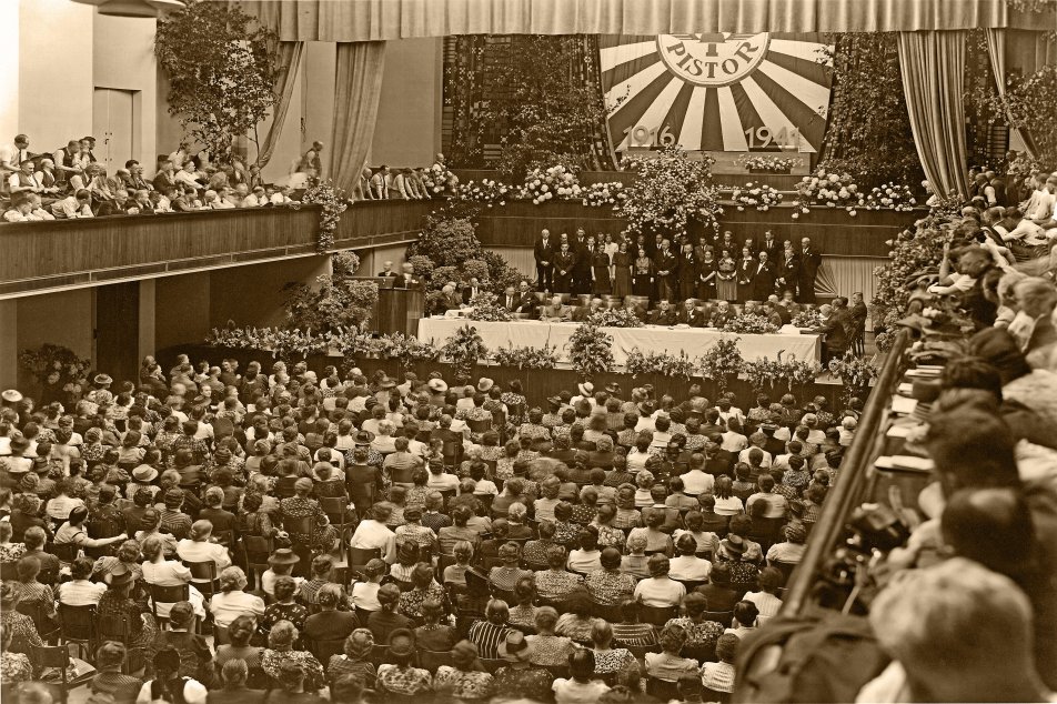 25-Jahr-Jubiläumsfeier von Pistor im Kunsthaus Luzern. Auf der Bühne sind Verwaltungsrat, Geschäftsleitung und Mitarbeitende von Pistor, 1941.
